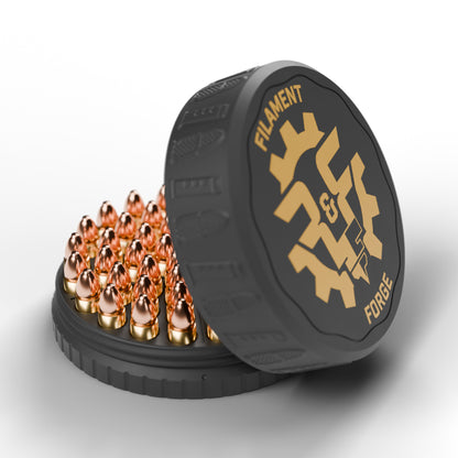F&F 50-round 9mm ammo puck open with 50 rounds, black lid with bullet-and-magazine texture and gold Filament & Forge badge leaning beside it