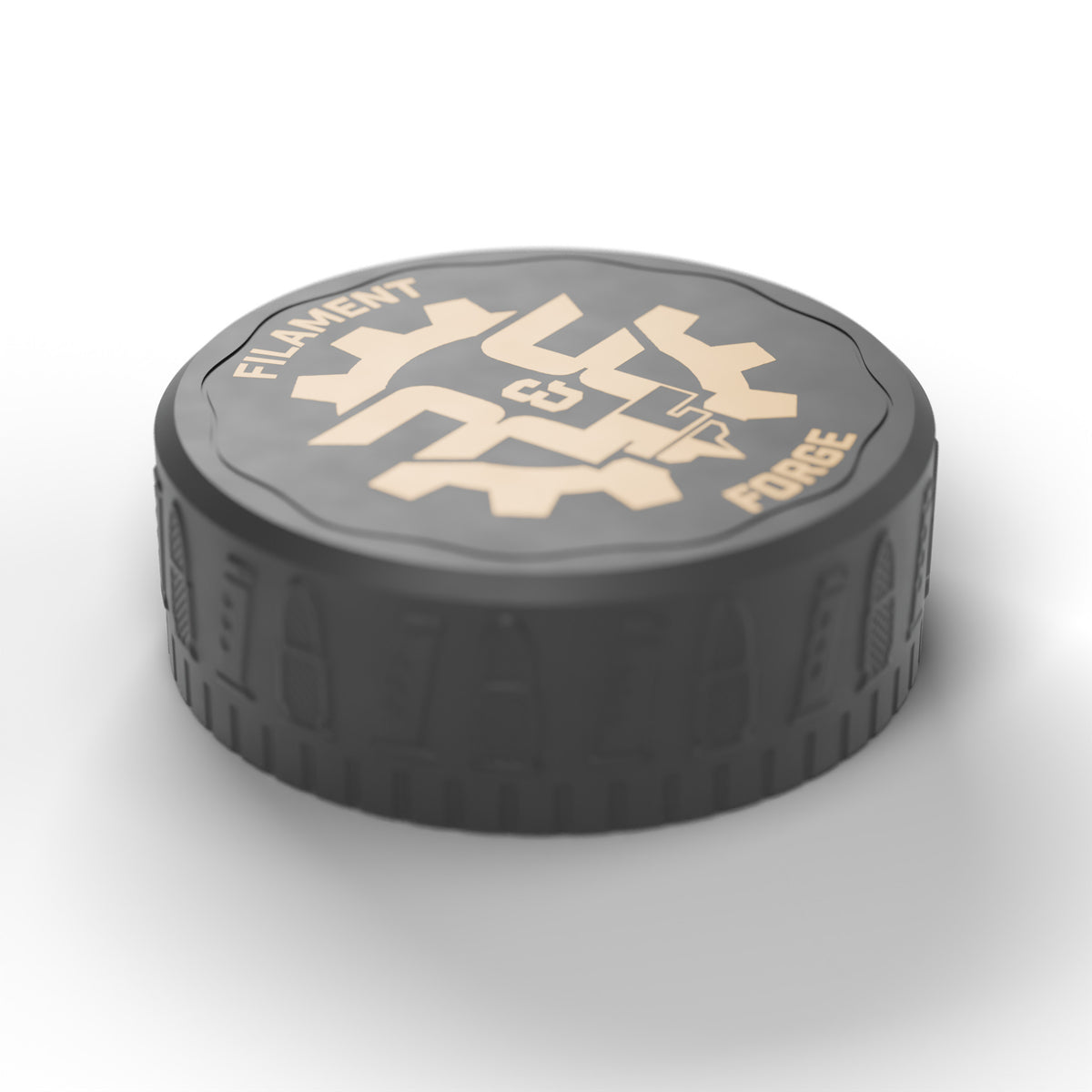 Closed F&F 50-round ammo puck, three-quarter view of the bullet-and-magazine textured lid and gold Filament & Forge badge