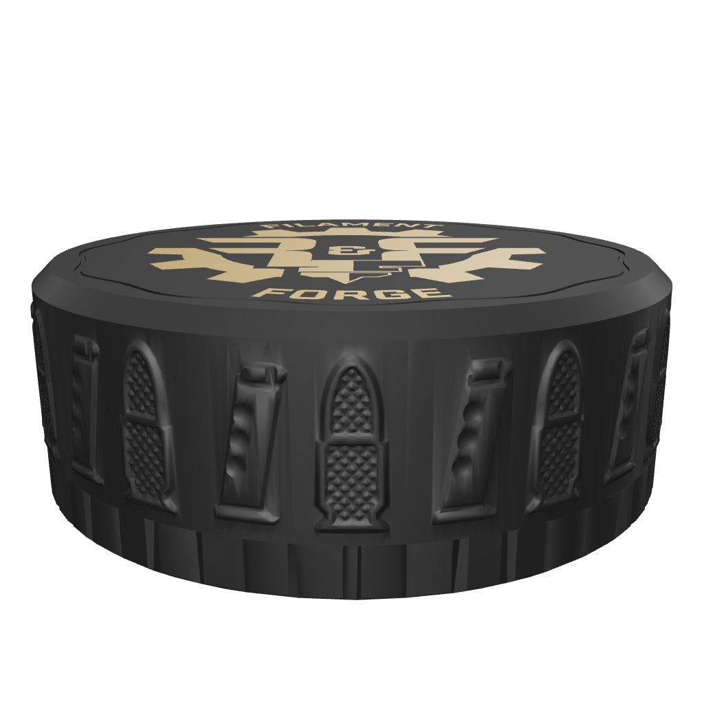 Interactive 3D model of the F&F 50-round 9mm ammo puck with the lid screwed on: black bullet-and-magazine textured lid with gold Filament & Forge badge. Drag to rotate, pinch or scroll to zoom.